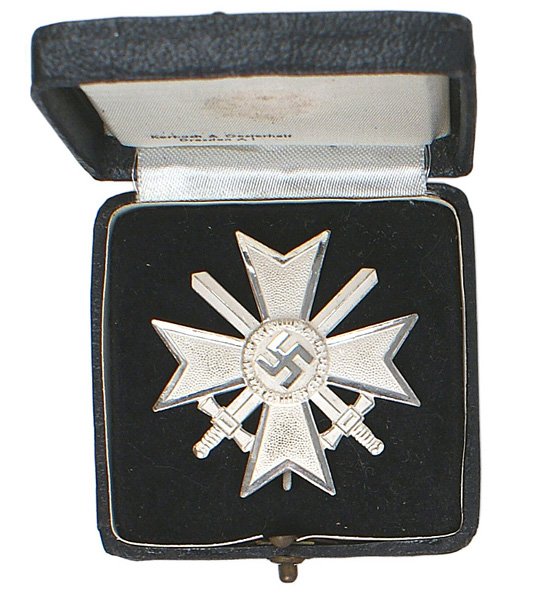 German WWII War Merit Cross Swords 1st Class: B-063 German WWII War Merit Cross with Swords 1st Class. Frosted pebbled silver cross with "polished" silver swastika highlights and border. Reverse of pin is maker marked "62". A superb example. With