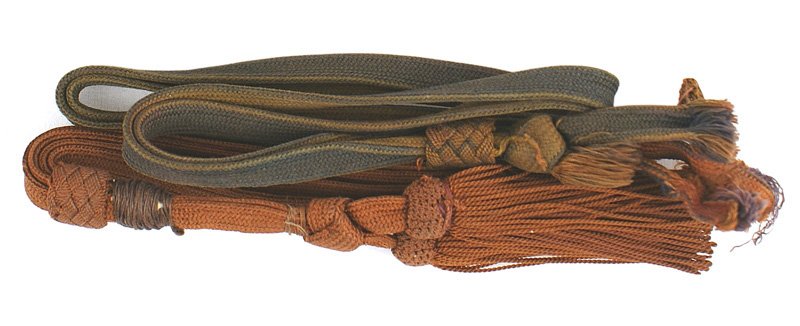 Lot of 2 Japanese WWII sword portopees: D-161 Lot of 2 Japanese WWII sword portopees: (1) Gold-brown shortened to 8 1/4" with 2 tassels (2) Same as above but faded and missing tassels. About II