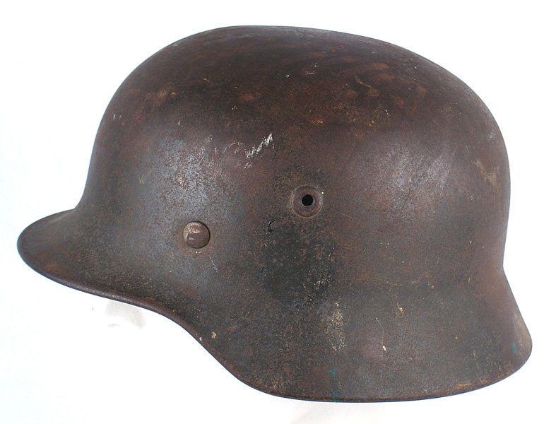 German WWII Army M1935 combat helmet: E-124 German WWII Army M1935 combat helmet. Outline is visible where decal was removed. Finish shows wear especially along the top. Well worn leather liner with the perimeter having a "chewed" look. H
