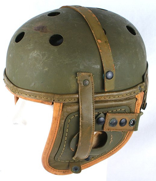 U.S. WWII tanker helmet: E-151 U.S. WWII tanker's helmet. O.D. hard leather, football-type with round perforations across the top. Ear flaps with compartments to accommodate earphones. Tan leather drawstring liner is marked w
