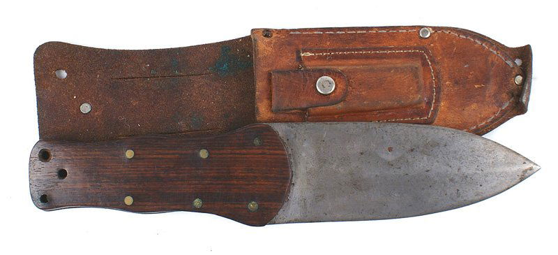 Post WWII U.S. Navy Pilot Survival knife: D-252 Post WWII U.S. Navy Pilot's Survival knife. Unusual "coke bottle" shaped flat wood grip with 6 brass rivets. Wide "gladius" shaped 5 1/4" blade. Graying with several dark spots. Leather scabbard