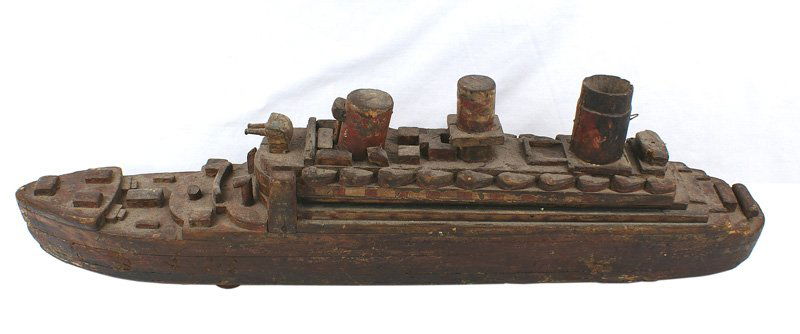 Wood pull-toy QUEEN MARY: H-143 Wood, multiple-piece construction, pull-toy named the "QUEEN MARY". Three smokestacks, a gun emplacement, life boats, etc. Shows age and wear. 4 wood wheels. 29" long x 8 1/4" high. (The origina
