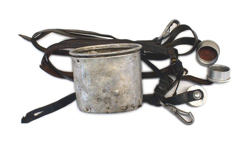 German WWII canteen accessory lot: N-008 German WWII canteen accessory lot: (1) Metal cup - dated "38". (2) Three leather harness canteen holders. All with the attached metal cap and belt snap. One is dated "39" (small throat strap tor