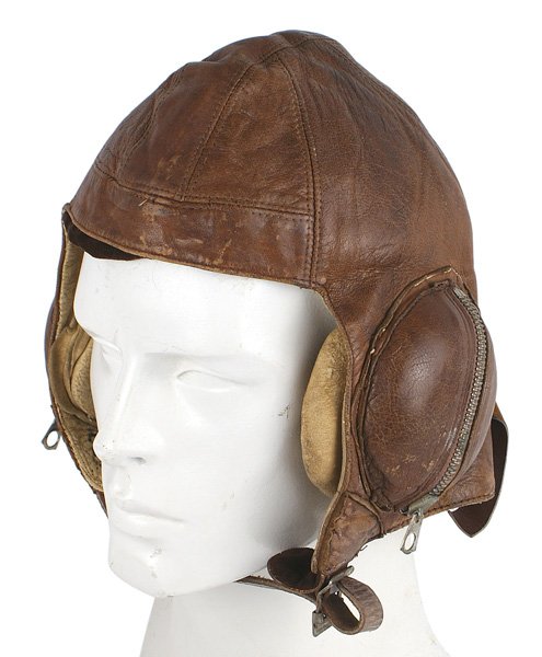 Canadian WWII flight helmet: E-054 Canadian WWII leather flight helmet. Same pattern as the British "Battle of Britain" type. Brown leather with zippered ear phone cups. Chamois lined/padded ears and stamped "RCAF". Name of owner