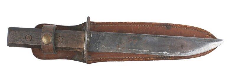 American GI made WWII combat knife: D-044 American GI made combat knife. Beveled wood grips with 2 screw rivets. Oval steel crossguard. 7 1/4" handmade blade.. Graying with some dark age spotting. Leather scabbard/retaining strap is mar