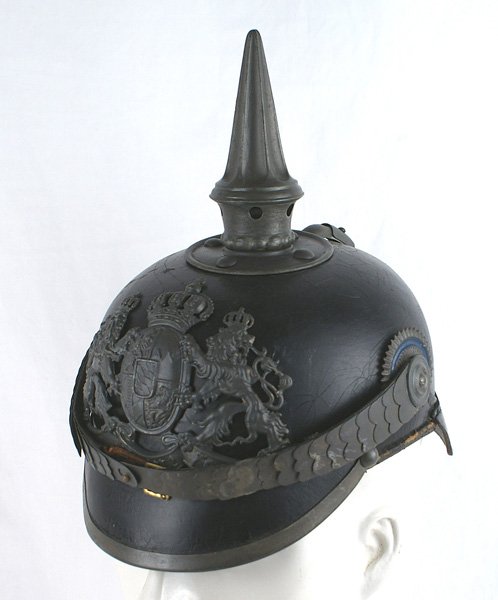Imperial German Bavaria NCO helmet: E-003 Imperial German Bavaria. NCO wartime helmet. Solid black leather body showing some small surface "spiders" on the back. Subdued field gray finish on the front plate, flat chinscales, fluted spik