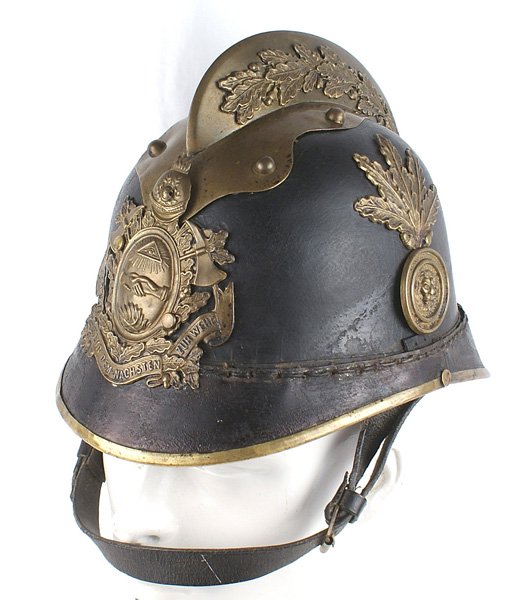 Imperial German Fire Department Officer helmet: E-027 Imperial German Fire Department Officer helmet. Military style black leather skull with brass trim full front and reverse brims. Brass comb with applied relief oak leaves and a spray of brass oa