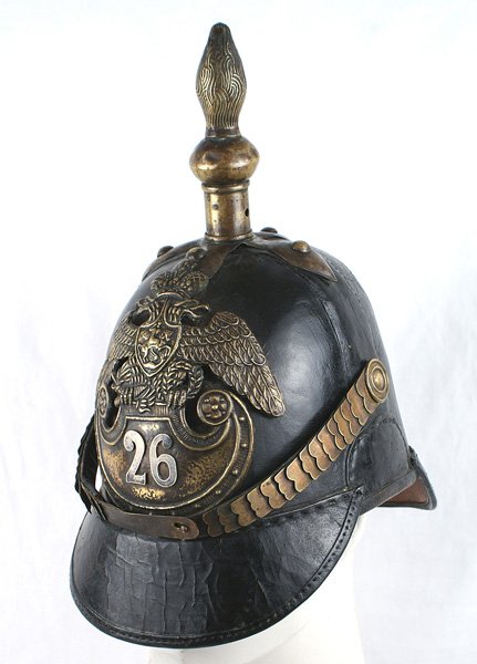 Imperial Russian 26th Infantry Regiment helmet: E-031 Imperial Russian, 26th Infantry Regiment, pattern 1846 other ranks helmet. Melon shaped black leather body with 2 1/2" sloped visors. Age darkened brass fish-scale chinstrap/bosses and cross bas