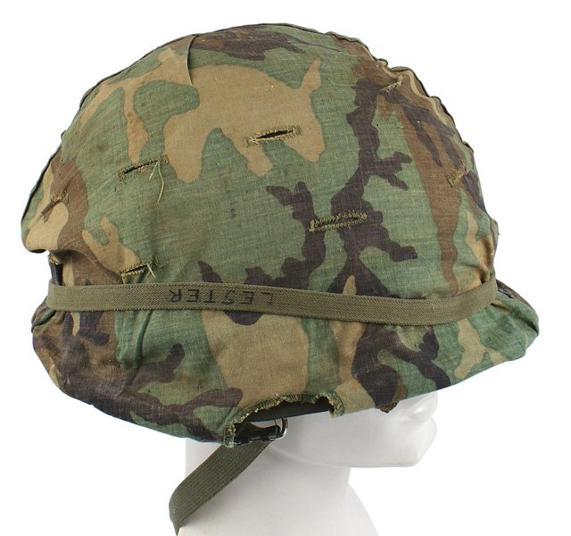 U.S. Vietnam era named helmet: E-061 U.S. Vietnam era named helmet. O.D. "sand" finish. Split-seam in front. Swivel bale. Web chinstrap. Camouflage cover. Para type fiber liner with "Y" type web straps (chinstrap missing). Two of t