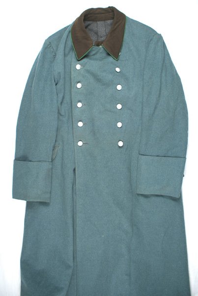 German WWII Police Service overcoat: F-050 German WWII Police Service winter overcoat. Green-gray material with a green piped brown collar. Two rows, of six each, silvered pebbled buttons. Wool lining with an interior pocket and "slit" f