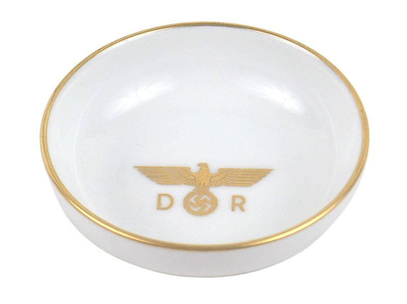 Hermann Goring private dining butler dish: A-031 Hermann Goring's personal, private dining car butler dish. Same white bone porcelain pattern as above. 3 7/8" diameter. Gold leaf eagle/swastika and "DR" with a gold leaf border. Marked "Nymphen