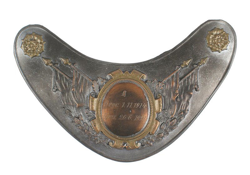 German WWI memorial gorget: H-120 German memorial gorget. Typical mid-20th century style with a darkened gray finish and an age toned center of crossed flags and engraved "Gegr. 1.11.1914 - Gest. 26.6.1919". Floral designed boss
