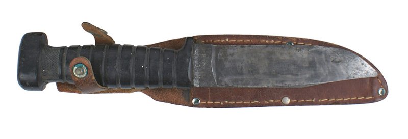U.S. WWII Colonial Navy knife: D-061 U.S. WWII "Colonial" Navy knife. One piece bakelite ribbed grip/pommel. 5" blade is marked "U.S.N." and "MARK 1 - COLONIAL". Blade shows use and wear. Leather scabbard with "slits" and retaining