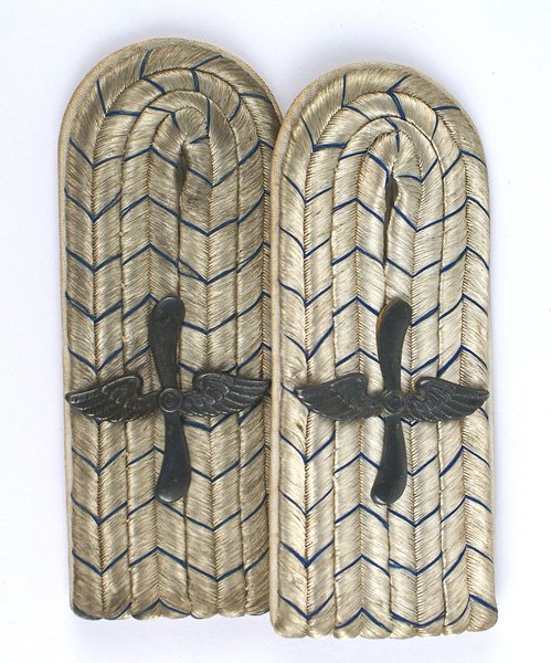 Bavarian Pilot shoulder boards: S-131 Imperial German Bavarian Pilot's shoulder boards. Darkened winged propeller insignia affixed to silver wire cord with blue "V's" and white underlay. One is more age toned. Slip-on type. II