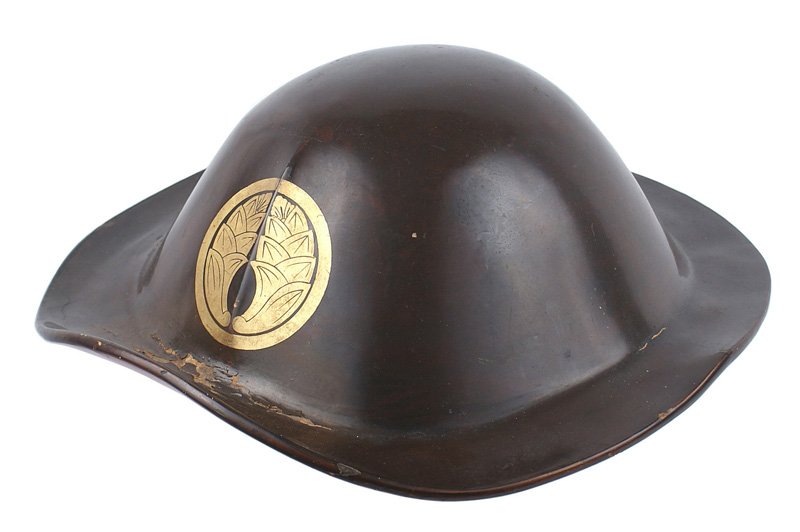Japanese Jingasa ceremonial helmet: R-002 Japanese "Jingasa" - dark brown lacquered wood ceremonial/parade helmet. High rounded skull, wide brim and turned up front brim. Large gold "mon" on front. Red lacquered interior with 4 small ey