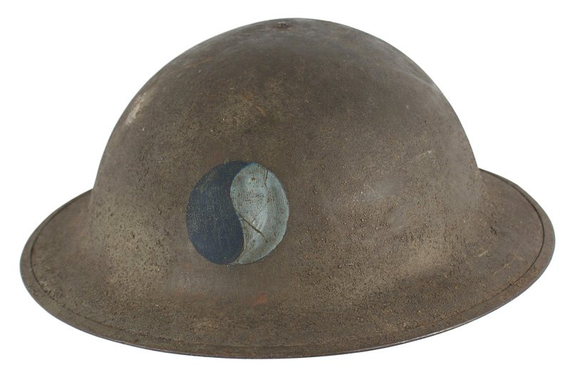 U.S. 29th Division WWI doughboy helmet: E-045 U.S. 29th Division WWI "doughboy" helmet. Rough sand finish OD helmet. Round disc divided into two different shades of blue panels. Complete liner and chinstrap named to "David Ayla". II