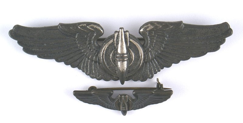 U.S. WWII Bombardier wings: B-370 U.S. Bombardier wings WWII. Downward pointed bomb on the center of a winged target. 90% of the applied darkened finish still remains. Reverse marked "GEMSCO-STERLING". Horizontal pin. With a 1 3
