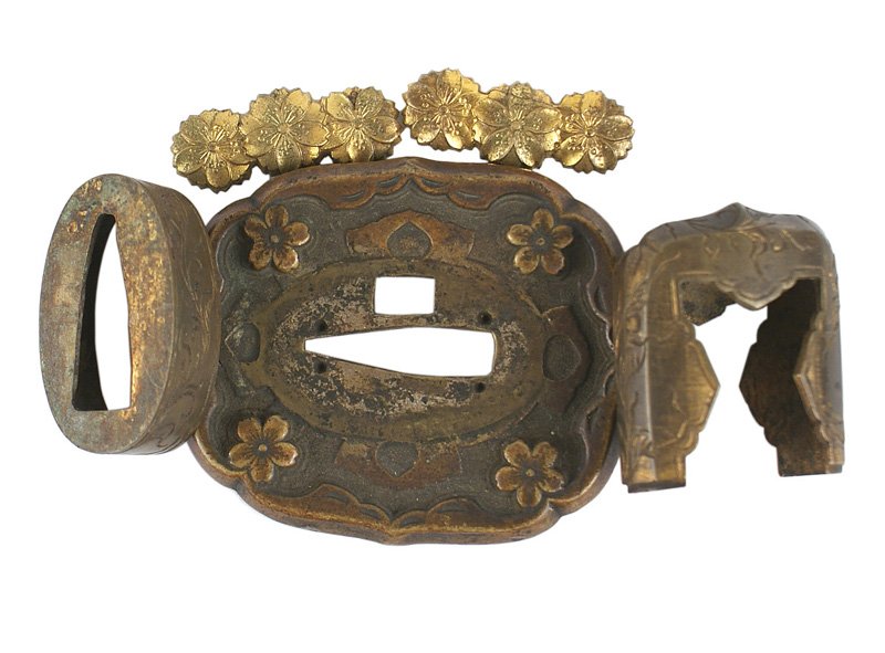 Japanese Officer samauri sword fittings: D-091 Set of fittings for a Japanese Officer's samauri sword. Includes: (1) tsuba - aged toned brass with a relief plum blossom in each corner. (2) Brass pommel cap with engraved floral work. (3) Ferr