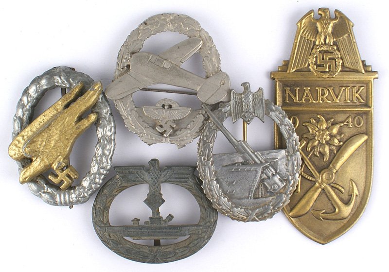 Lot of German WWII reproduction badges: H-194 Lot of Third-Reich reproduction badges: (1) Narvik Shield-Gilt. (2) Luftwaffe Paratrooper Badge. (3) Navy Submariners Badge. (4) Navy Coastal Artillery. Marked "R.S.". (5) NSFK Powered Aircraft 