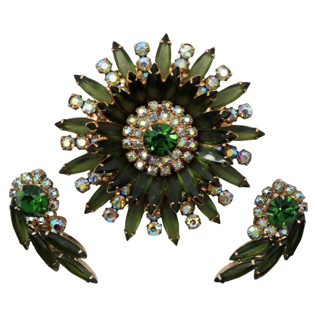 Juliana (Attributed) Green Rhinestone Starburst Brooch and Earrings Demi-Parure: Summary This vintage mid-20th century rhinestone demi-parure consists of a dramatic layered starburst brooch with matching clip earrings. The design features deep emerald green navette-cut glass stone