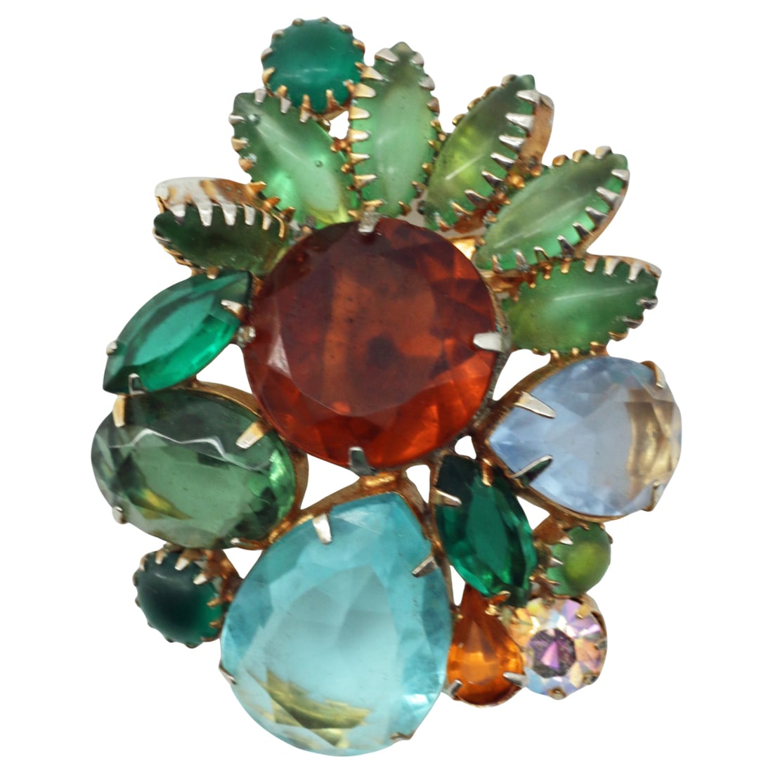 Vintage Jewel-Tone Glass Fruit Salad Style Cluster Brooch: Summary Vivid jewel-tone glass stones in aqua, emerald, peridot green, and warm amber cluster together in a dimensional mid-century composition. Faceted pear, oval, and round stones mingle with froste