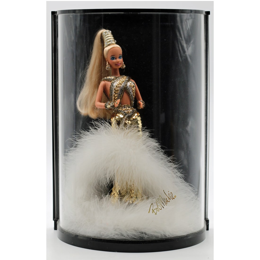 1990 Bob Mackie Gold Barbie in Display Case: Identification Mattel 1990 Bob Mackie "Gold" Barbie, vinyl fashion doll with sequined couture-style gown and marabou trim, late 20th century American designer collaboration. Presented in original curv