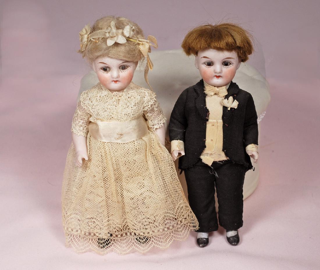 92. GERMAN ALL-BISQUE DOLLS AS BRIDE AND GROOM. Marks:: 92. GERMAN ALL-BISQUE DOLLS AS BRIDE AND GROOM. Marks: 5084. 6". Each is all-bisque, jointed at shoulders and hips, stationary brown glass eyes, painted lashes, tapered brows, closed mouth, original w