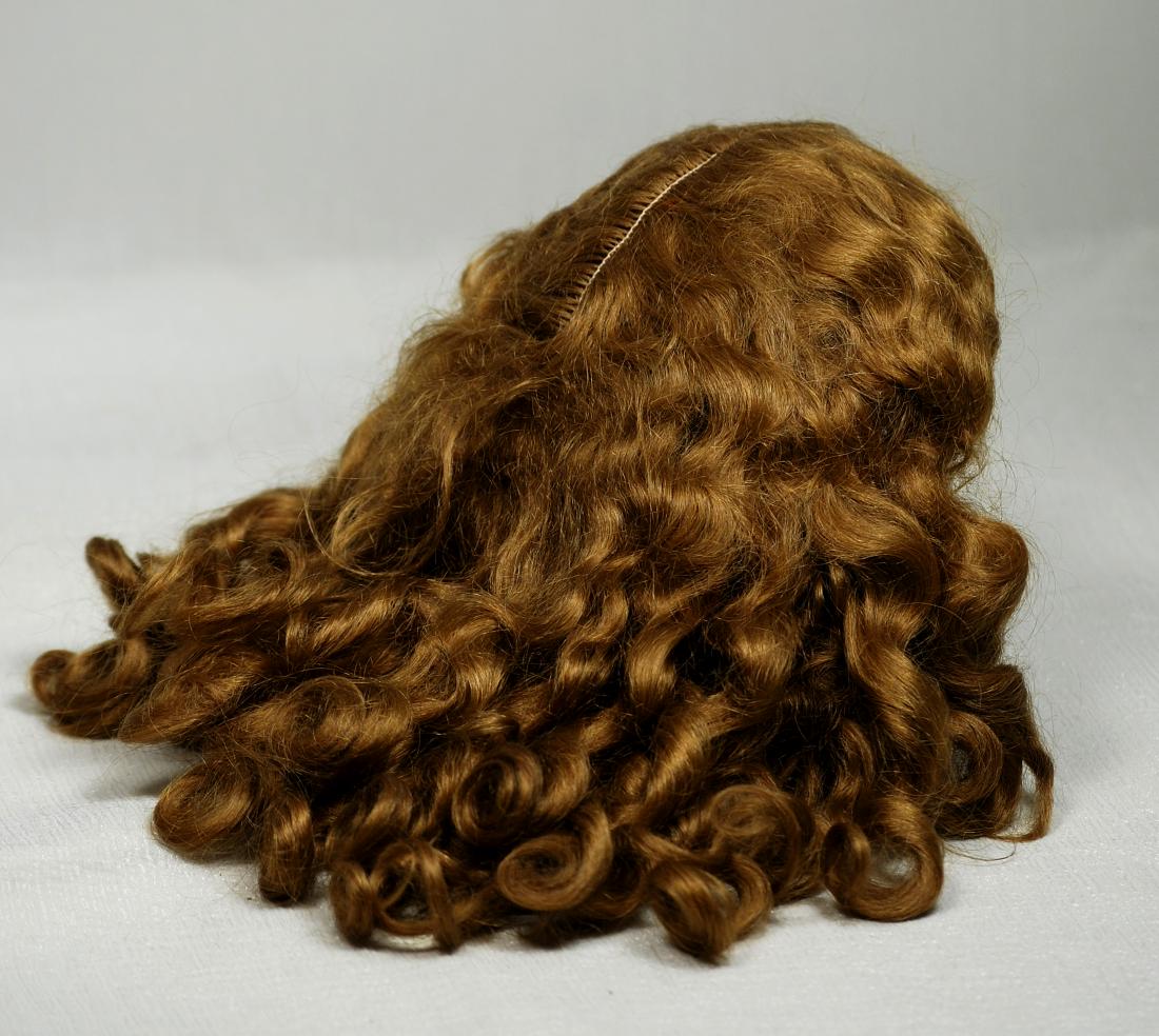 148. GORGEOUS ANTIQUE DOLL WIG. Warm brown mohair wig: 148. GORGEOUS ANTIQUE DOLL WIG. Warm brown mohair wig is center-parted with waves and curls tumbling downward about 10”-11” from center crown, fits 12”-13” head circumference.