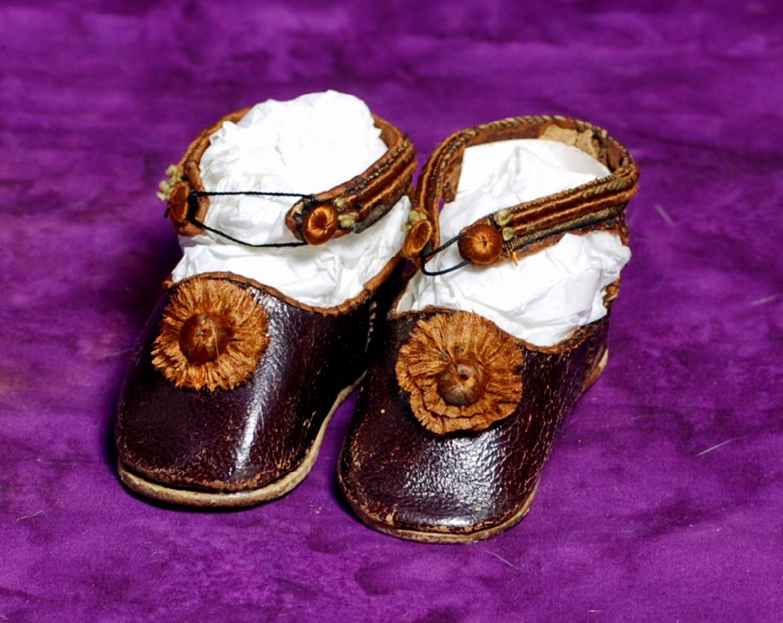 233. PAIR OF ANTIQUE DOLL SHOES. Marks: Made in: 233. PAIR OF ANTIQUE DOLL SHOES. Marks: Made in Germany. 3” L rich brown leather shoes with ankle strap closing and large silk rosettes. Commentary: Very good original condition.