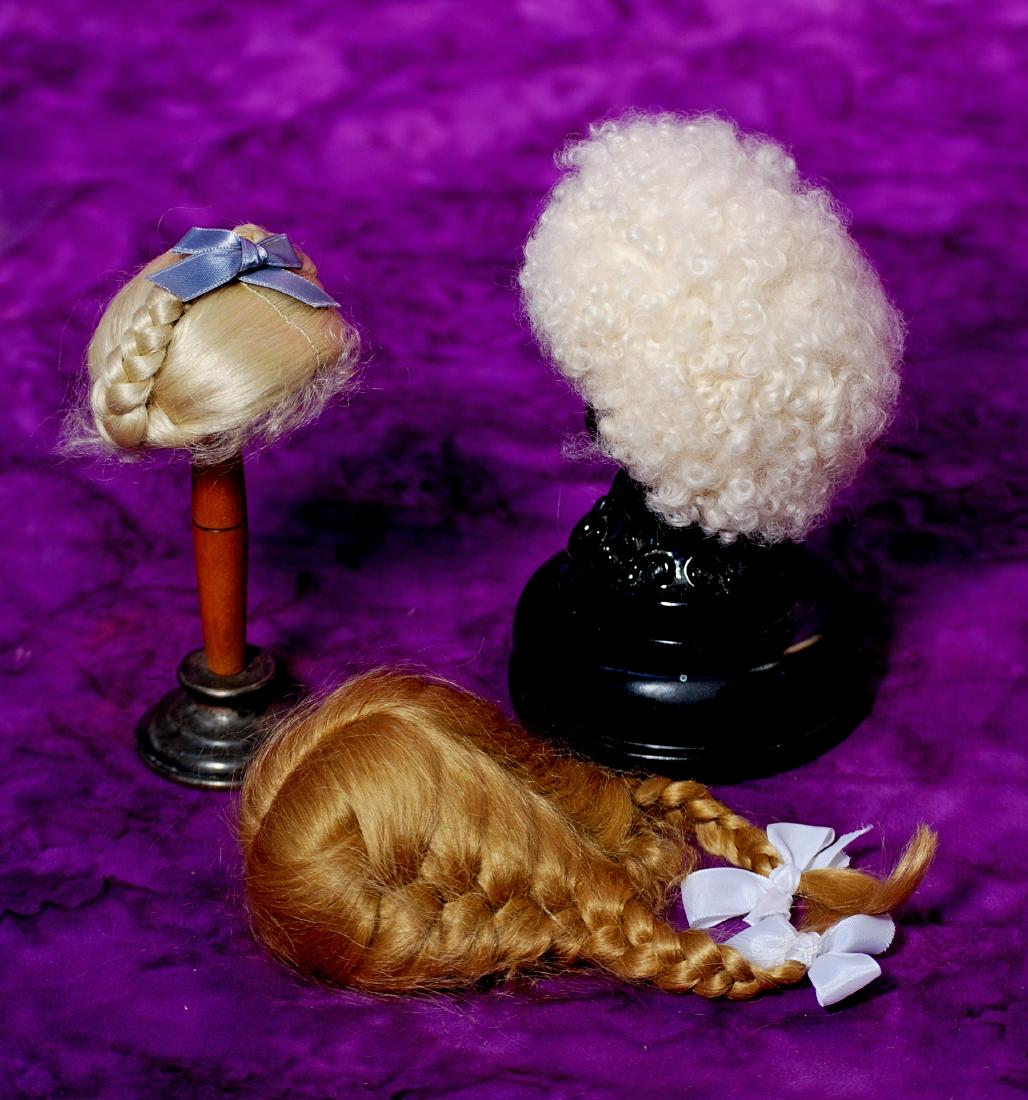 249. THREE DOLL WIGS. Soft lamb skin wig for about: 249. THREE DOLL WIGS. Soft lamb skin wig for about 7” h.c.; pale blonde mohair wig with braids over crown, for about 6” h.c.; dark blonde mohair wig in braids, for about 7” h.c. All