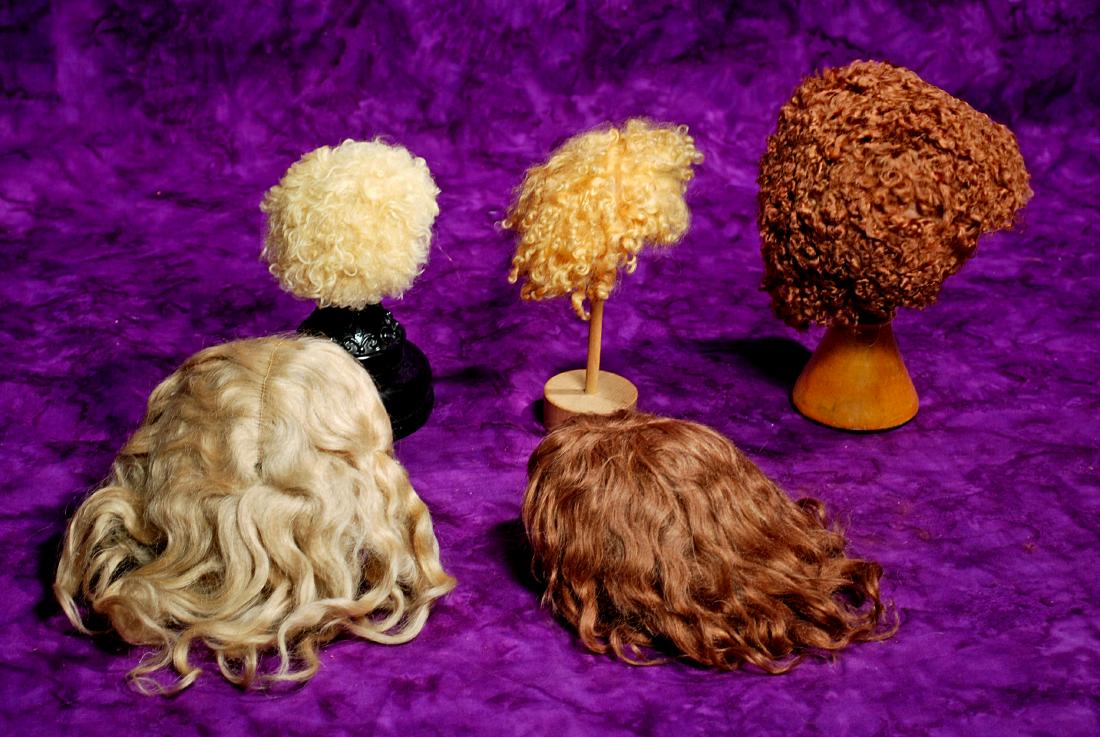 278. FIVE DOLL WIGS. Two blonde lambs wool wigs for: 278. FIVE DOLL WIGS. Two blonde lambs wool wigs for about 7” h.c., brown lambs wool wig for 14”-15” h.c., antique blonde mohair center-part wig for 11” h.c., and antique light