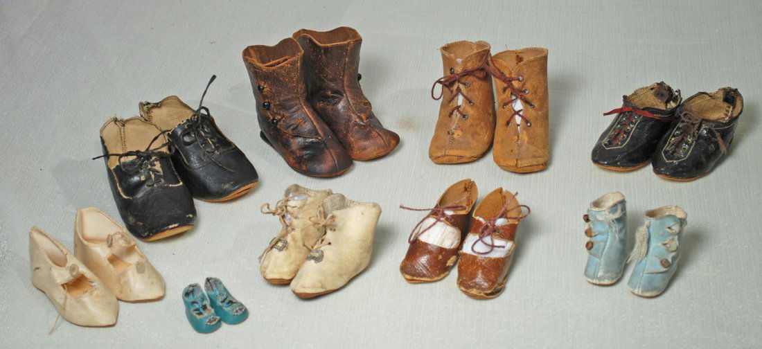 NINE PAIRS OF DOLL SHOES AND BOOTS: 309. NINE PAIRS OF DOLL SHOES AND BOOTS. Assorted sizes and styles, fair to good condition with wear and some missing buttons.