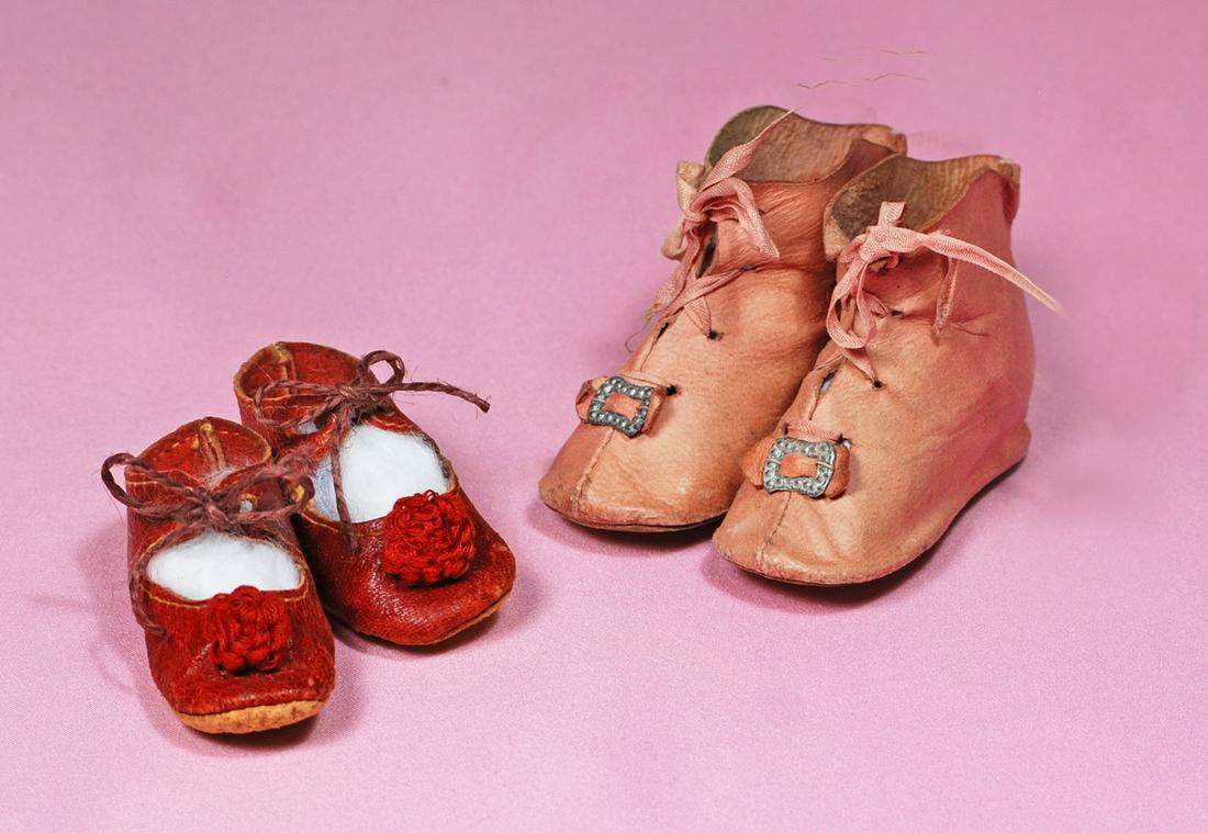 49. PAIR OF RED LEATHER DOLL SHOES & PINK LEATHER: 49. PAIR OF RED LEATHER DOLL SHOES & PINK LEATHER BOOTS. Soft red leather shoes with rosettes and tie closing, 2.25”. Rose-pink boots with front lace closing, leather bows and silver buckles, 2.5”