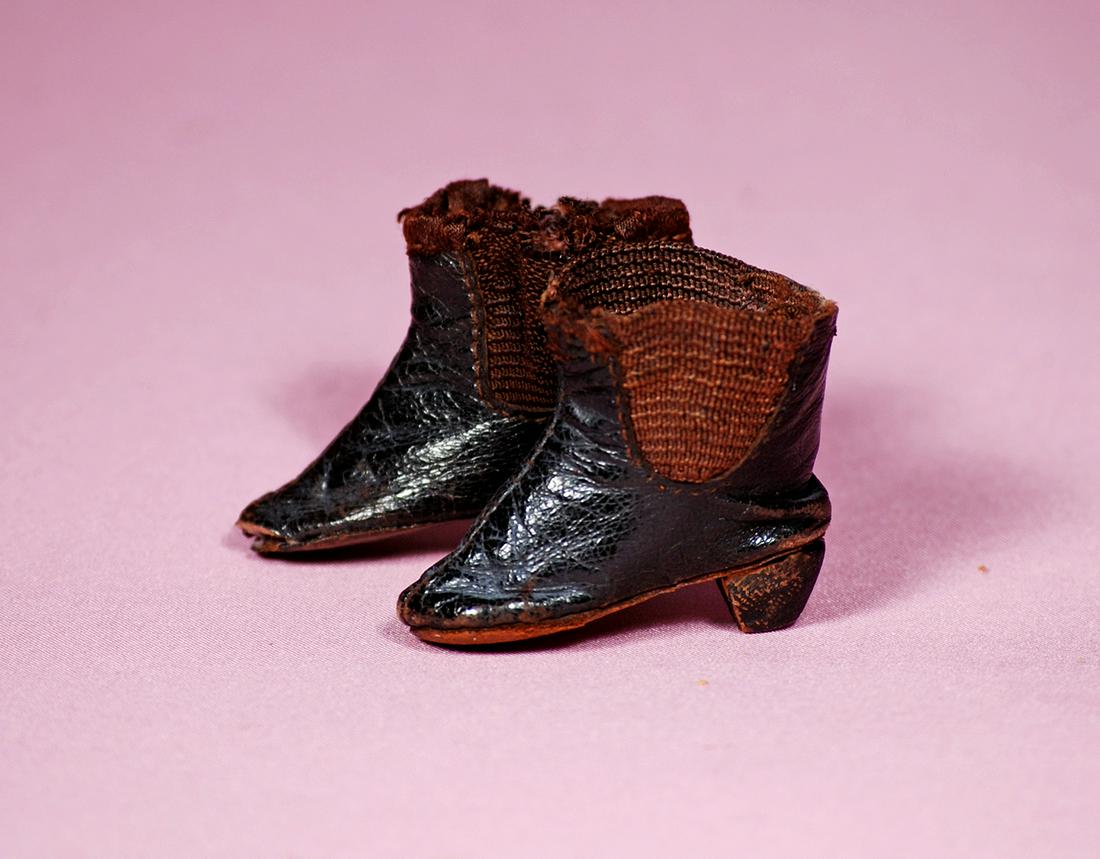 105. PAIR OF ANTIQUE LEATHER FASHION BOOTS. 1.25”.: 105. PAIR OF ANTIQUE LEATHER FASHION BOOTS. 1.25”. Dark leather boots with brown side gussets, tiny wooden heels. Commentary: Side gussets showing wear, otherwise good condition.