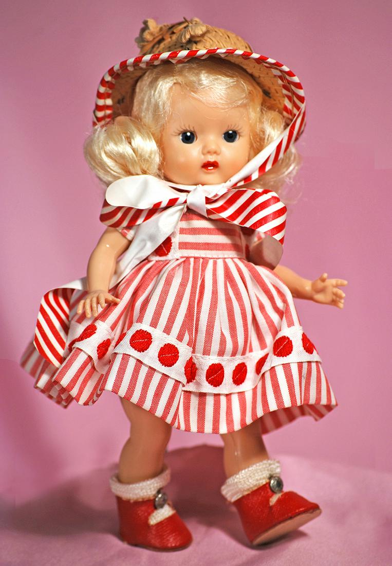 138. NANCY ANN STORYBOOK “MUFFIE” IN RED STRIPED: 138. NANCY ANN STORYBOOK “MUFFIE” IN RED STRIPED DRESS. 8”. Hard plastic strung doll, blue sleep eyes, painted curly lashes, ruby lips, side-parted platinum blonde wig in original set, wears red