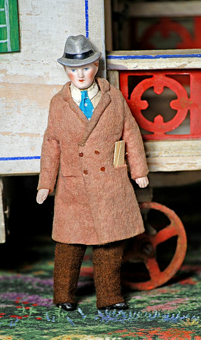 GERMAN BISQUE DOLLHOUSE MAN WITH SCULPTED HAT 5¼": GERMAN BISQUE DOLLHOUSE MAN WITH SCULPTED HAT 5 1/4" Bisque shoulderhead with sculpted gray hat, painted features, blue eyes, muslin body with bisque lower limbs, painted black boots, original costume
