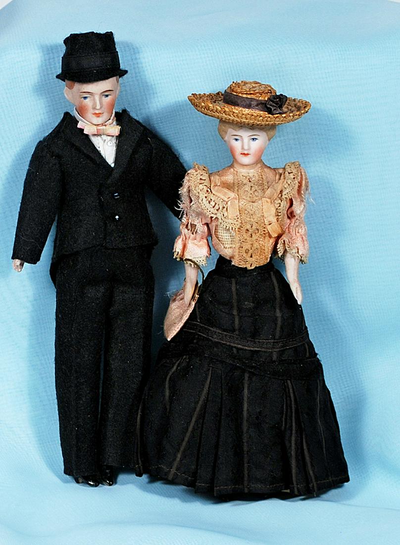 GERMAN BISQUE DOLLHOUSE GENTLEMAN AND LADY IN GIBSON: GERMAN BISQUE DOLLHOUSE GENTLEMAN AND LADY IN GIBSON GIRL DRESS 6 1/2" and 7" Each has bisque shoulderhead with sculpted hair and painted features, muslin body with bisque lower limbs; gentleman in da