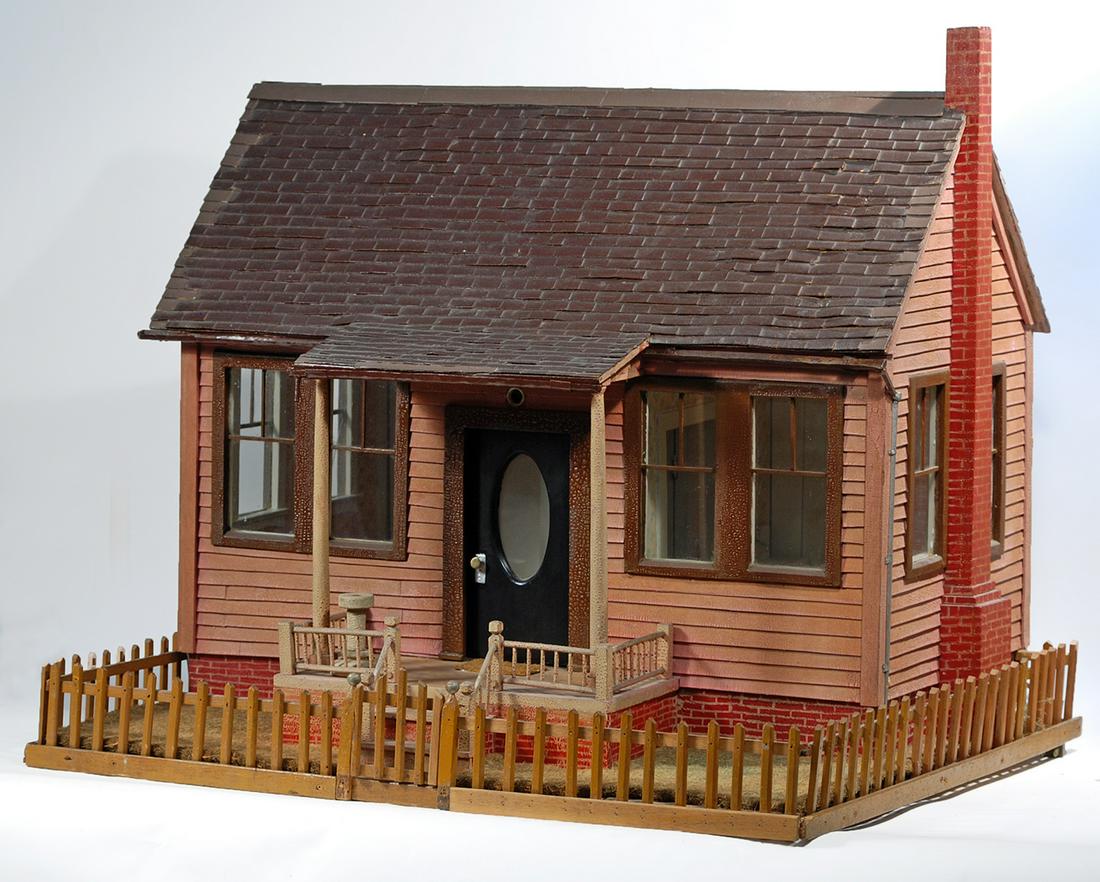 HANDCRAFTED DOLL HOUSE WITH PICKET FENCE 25" H x 28" W: HANDCRAFTED DOLL HOUSE WITH PICKET FENCE 25" H x 28" W x 23" D Tworoom house which opens at the back to reveal two interior rooms, foyer, and bathroom Brown shingled roof and tan clapboard siding, fau