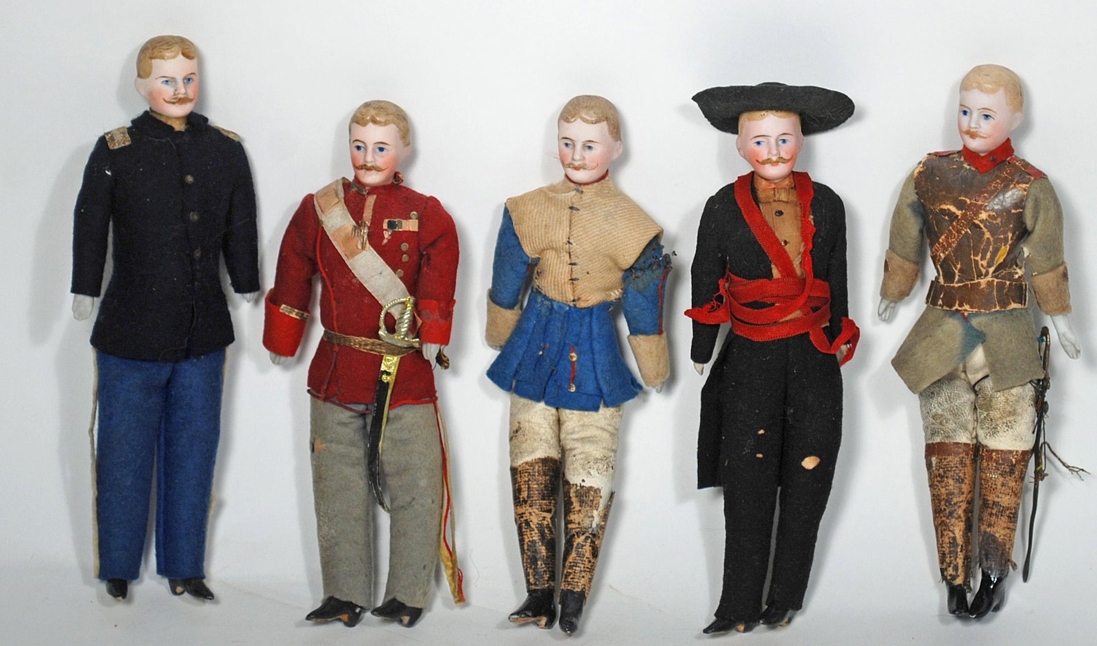 FIVE GERMAN BISQUE DOLLHOUSE MEN 7" Each is bisque: FIVE GERMAN BISQUE DOLLHOUSE MEN 7" Each is bisque shoulderhead with sculpted hair and moustache, muslin body with bisque lower limbs, painted black boots, dressed in original uniforms Commentary: Ori