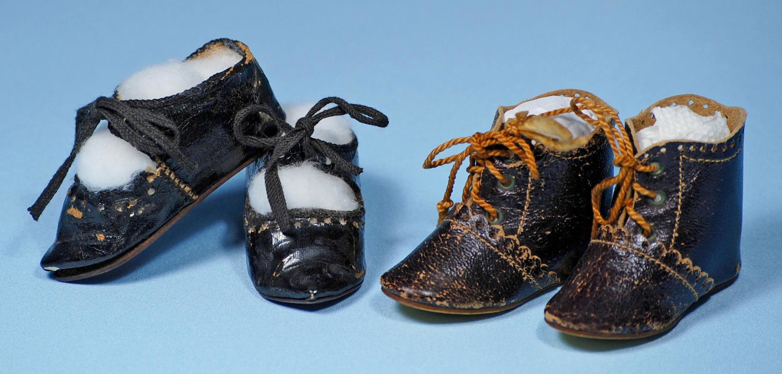 ANTIQUE PAIR OF DOLL SHOES AND BOOTS. 2 ½" l. pair of: ANTIQUE PAIR OF DOLL SHOES AND BOOTS. 2 ½" l. pair of black leather shoes with tie closing; 2 ½" L. pair of dark brown ankle boots with scalloped uppers and cord tie closing. Commentary: Good condit