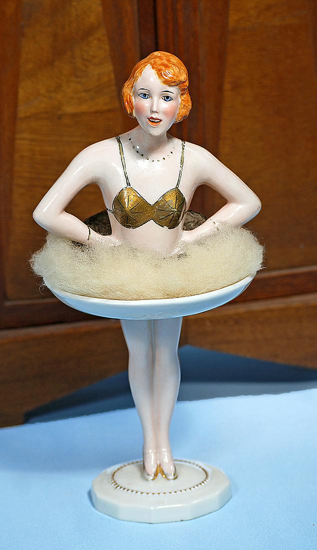 FRENCH PORCELAIN POWDER PUFF FLAPPER. Marks: Paris: FRENCH PORCELAIN POWDER PUFF FLAPPER. Marks: Paris France GM (stamp on bottom); Mallet Paris France (label on bottom). 9". Porcelain flapper style lady with side-parted auburn hair, gold halter top, n