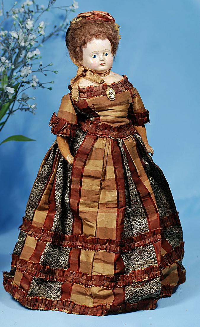 GERMAN PAPIER MACHE LADY DOLL IN ORIGINAL GOWN. 17".: GERMAN PAPIER MACHE LADY DOLL IN ORIGINAL GOWN. 17". Papier mache shoulderhead with plump face, painted features, outlined blue eyes, upper eyeliner, multi-stroked brows, closed mouth, original brown 