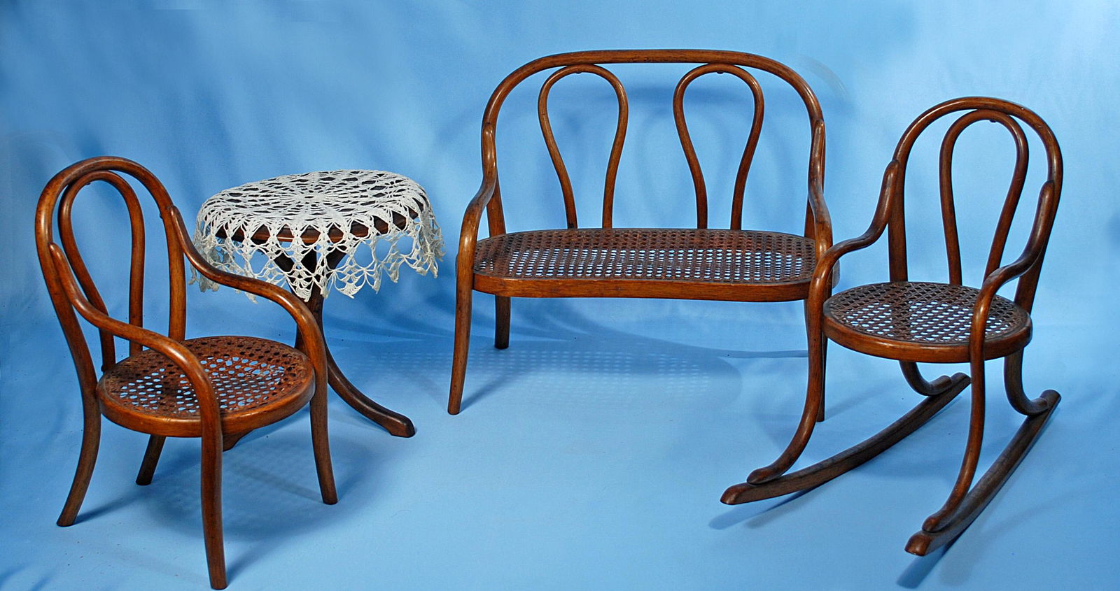 ANTIQUE BENTWOOD DOLL FUNITURE. Includes: Settee, arm: ANTIQUE BENTWOOD DOLL FUNITURE. Includes: Settee, arm chair, rocking chair, round table with lace cloth. Settee is 14" W. x 13" H. Good condition with original finish.