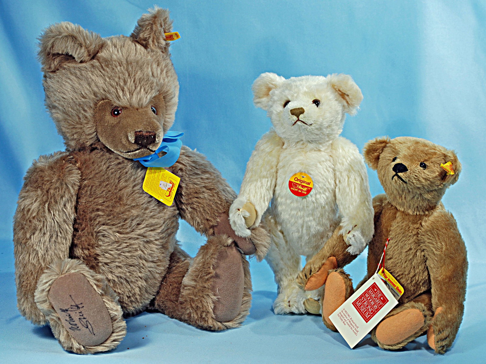 THREE STEIFF COLLECTOR BEARS. 12" replica of original: THREE STEIFF COLLECTOR BEARS. 12" replica of original white mohair bear; 12" tan mohair Margaret Strong Museum replica; 20" Steiff caramel mohair bear 0202/51. Each in mint condition.