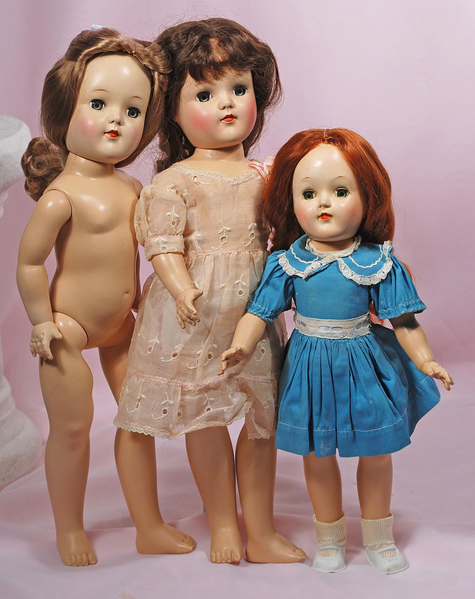 THREE HARD PLASTIC IDEAL TONI DOLLS: THREE HARD PLASTIC IDEAL TONI DOLLS. 14" and 19". Two 19" dolls marked P92, one nude and one in pink eyelet dress; 14" doll marked P-90 in original teal cotton dress, cotton slip and panty, vinyl shoe
