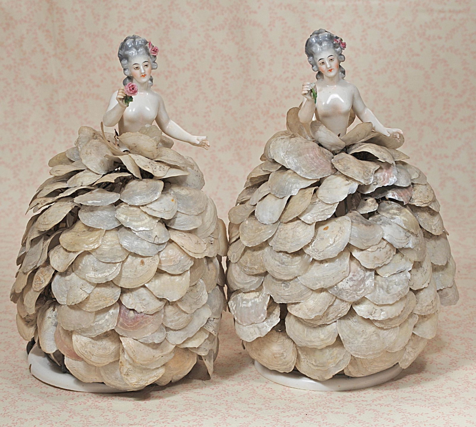 TWO PORCELAIN HALF DOLLS WITH ORIGINAL SHELL SKIRT LAMP: TWO PORCELAIN HALF DOLLS WITH ORIGINAL SHELL SKIRT LAMP. 12" overall. Each is porcelain nude lady, her head tilted downward gazing at the rose she holds in her hand, sculpted grey hair in long ringlet
