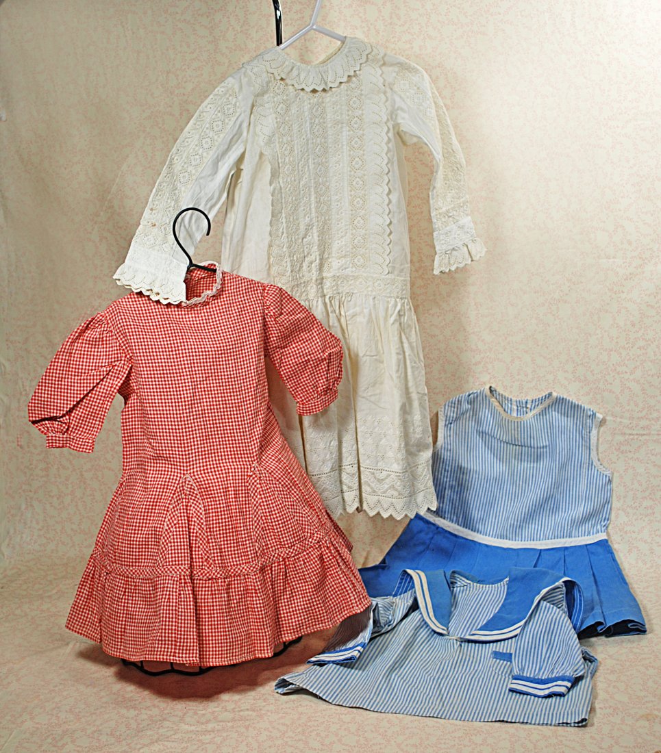 THREE COTTON DRESSES: 278.THREE COTTON DRESSES. Red and white cotton check dress, 8" shoulders, 17" length, princess style with inset triangular panels and skirt ruffle, back button closing; two-piece blue and white stripe
