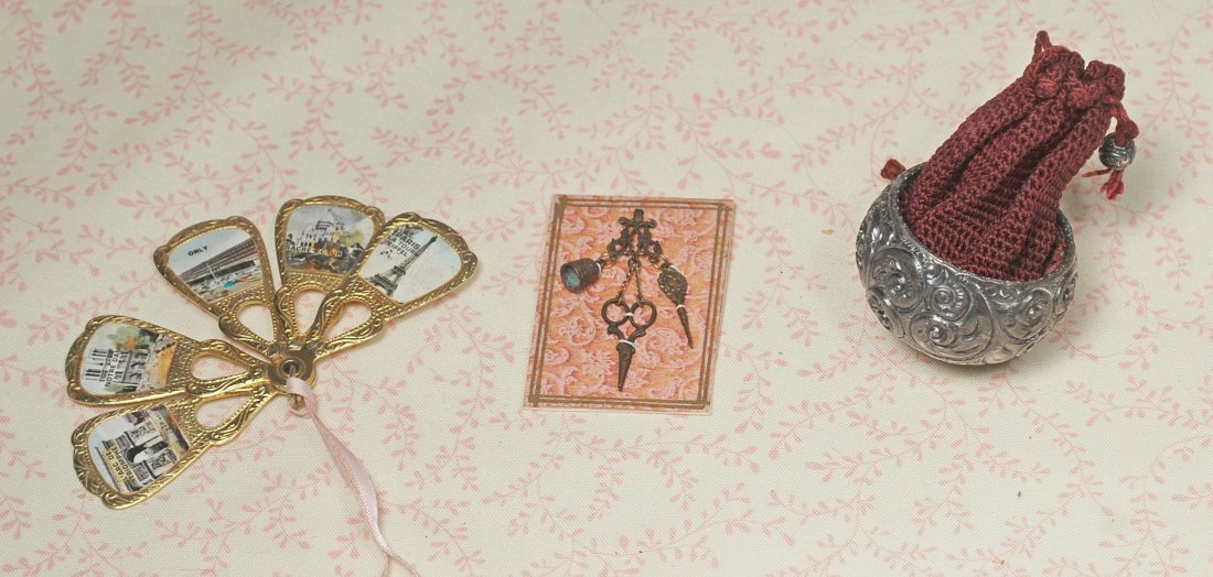 DOLL FAN, PURSE AND CHATELAINE: 242-A. DOLL FAN, PURSE AND CHATELAINE. 2" gilt metal five-blade fan with French scenes, 2" miniature chatelaine; Victorian-era embossed metal and maroon drawstring purse. Commentary: Fan and chatelain