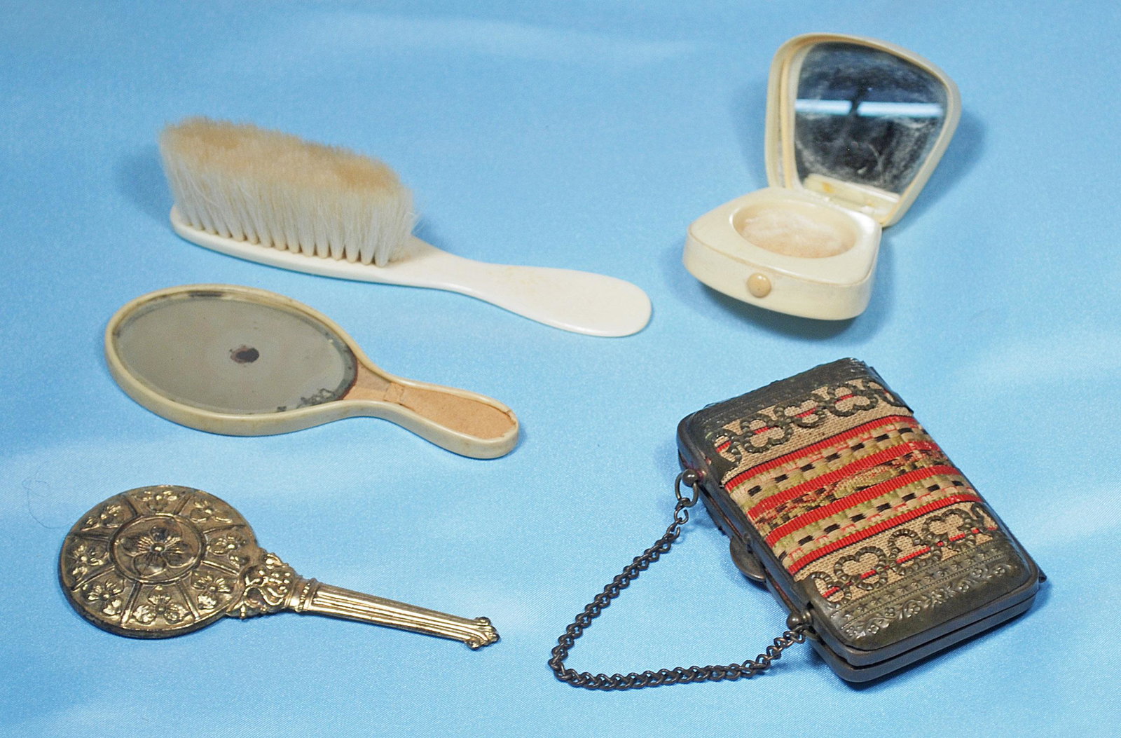DOLL ACCESSORY GROUP.: DOLL ACCESSORY GROUP. Includes Celluloid compact, hair brush and mirror; 4" embossed gilt hand mirror, tapestry and metal purse with link-chain handle and red interior with compartments, 3" width. Com