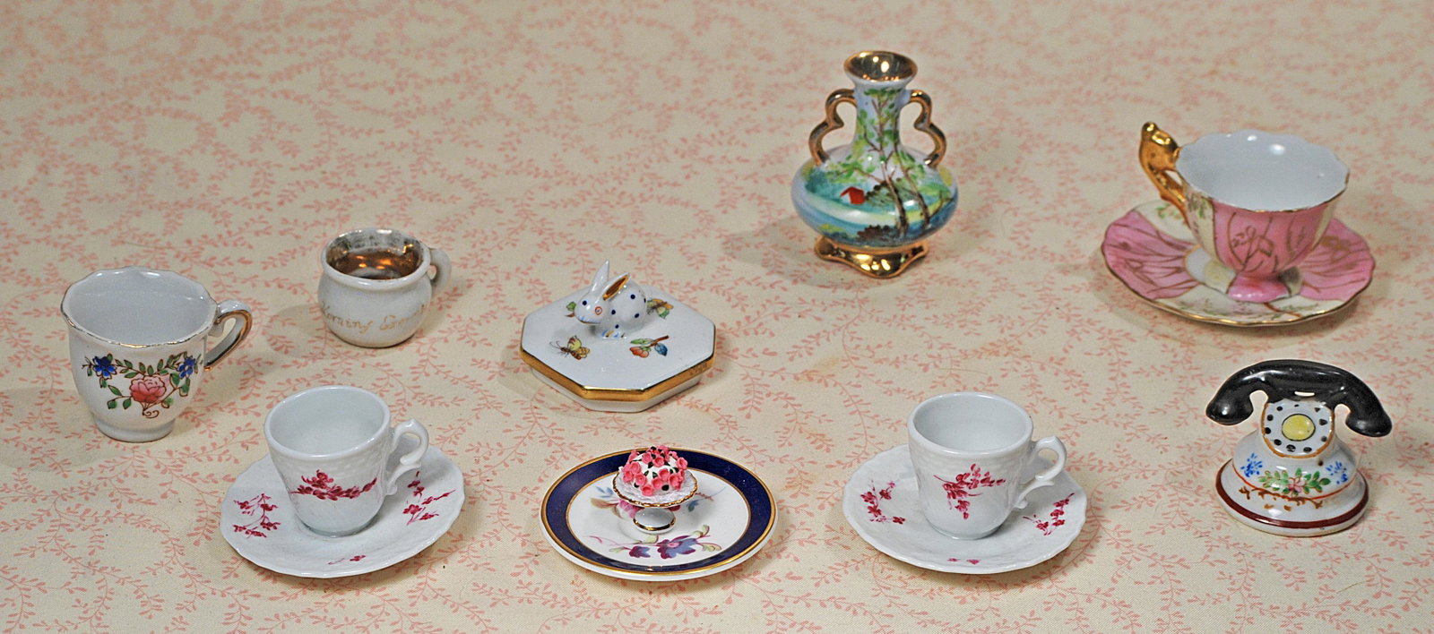 ASSORTED MINIATURE PORCELAIN DISHES AND NOVELTIES.: ASSORTED MINIATURE PORCELAIN DISHES AND NOVELTIES. Includes: 2 1/2" H. painted scenic vase with gilt trim, three cups and saucers, plate, souvenir cup, chamber pot, telephone and lid with bunny, tiny 